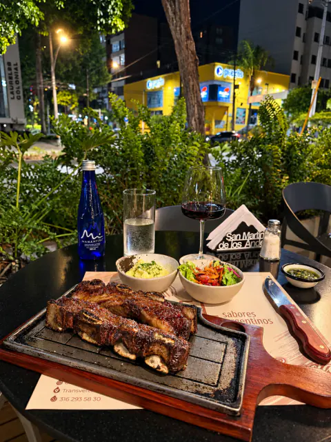 Asado de tira en tabla con ensaladas en la terraza