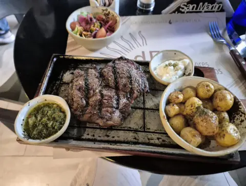 Bife a la parrilla con papas y chimichurri
