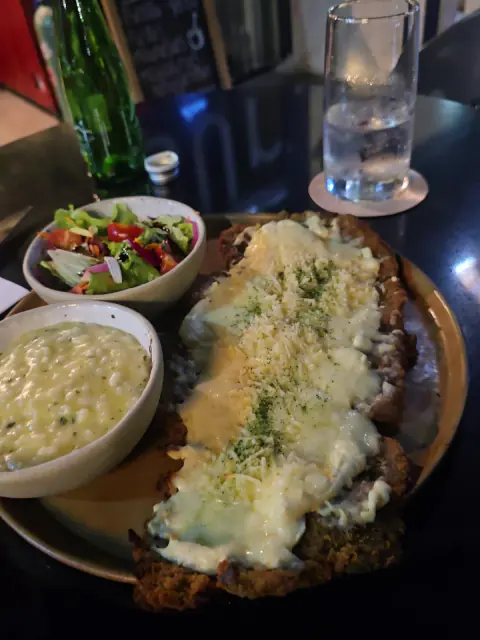 Milanesa gratinada con puré y ensalada